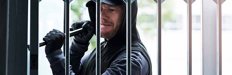 A burglar trying to break a security gate