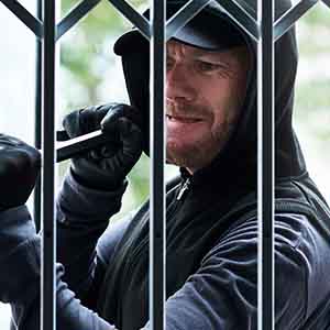 A burglar trying to break a security gate